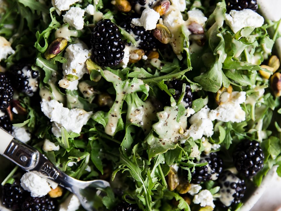 Arugula salad topped with blackberries, chevre, pistachios and a honey mustard salad dressing.