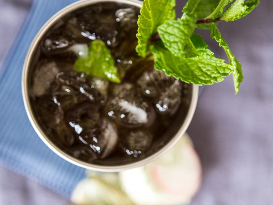 Mint julep in a silver cup topped with fresh mint