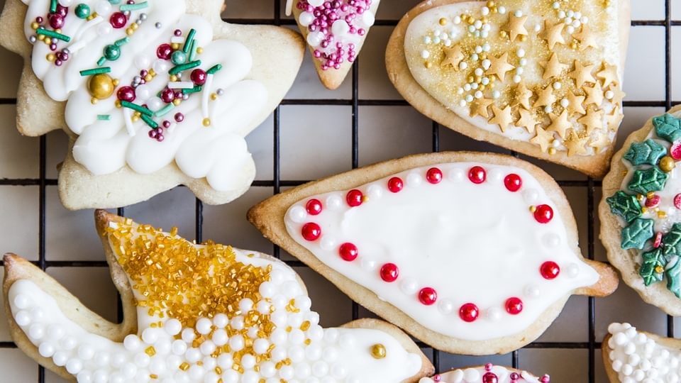 Decorated Sour Cream Sugar Cookies With Icing and sprinkles on a baking rack