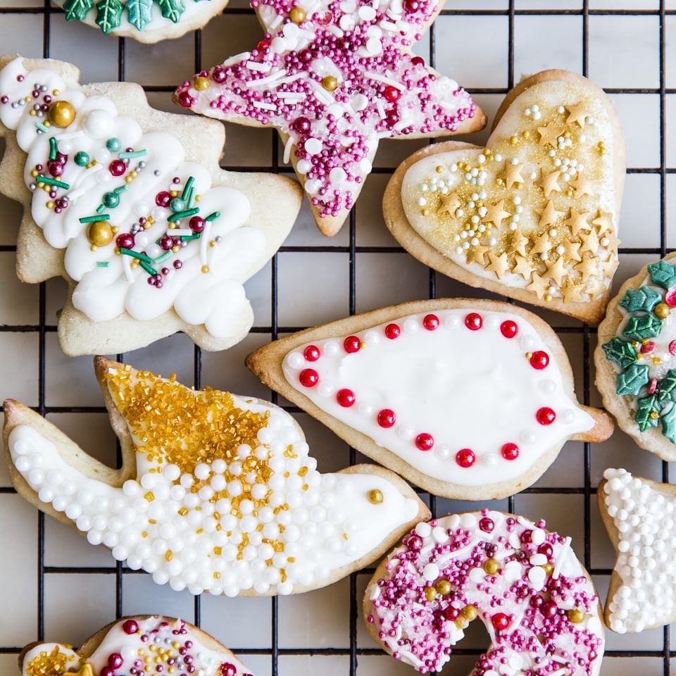 Decorated Sour Cream Sugar Cookies With Icing and sprinkles on a baking rack