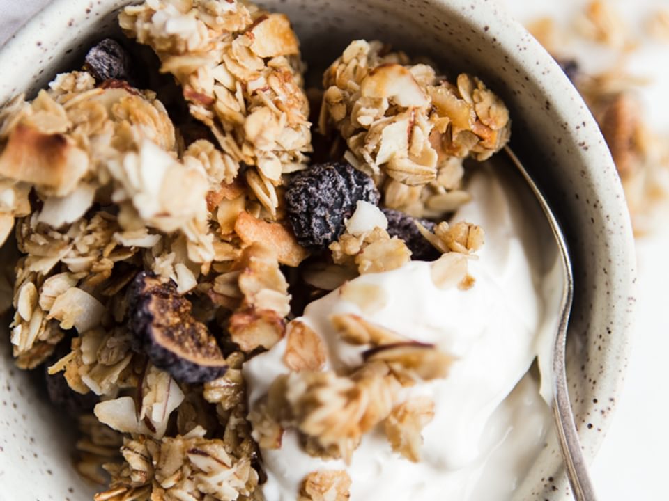 homemade vanilla granola with figs, almonds and coconut flakes in a bowl with yogurt