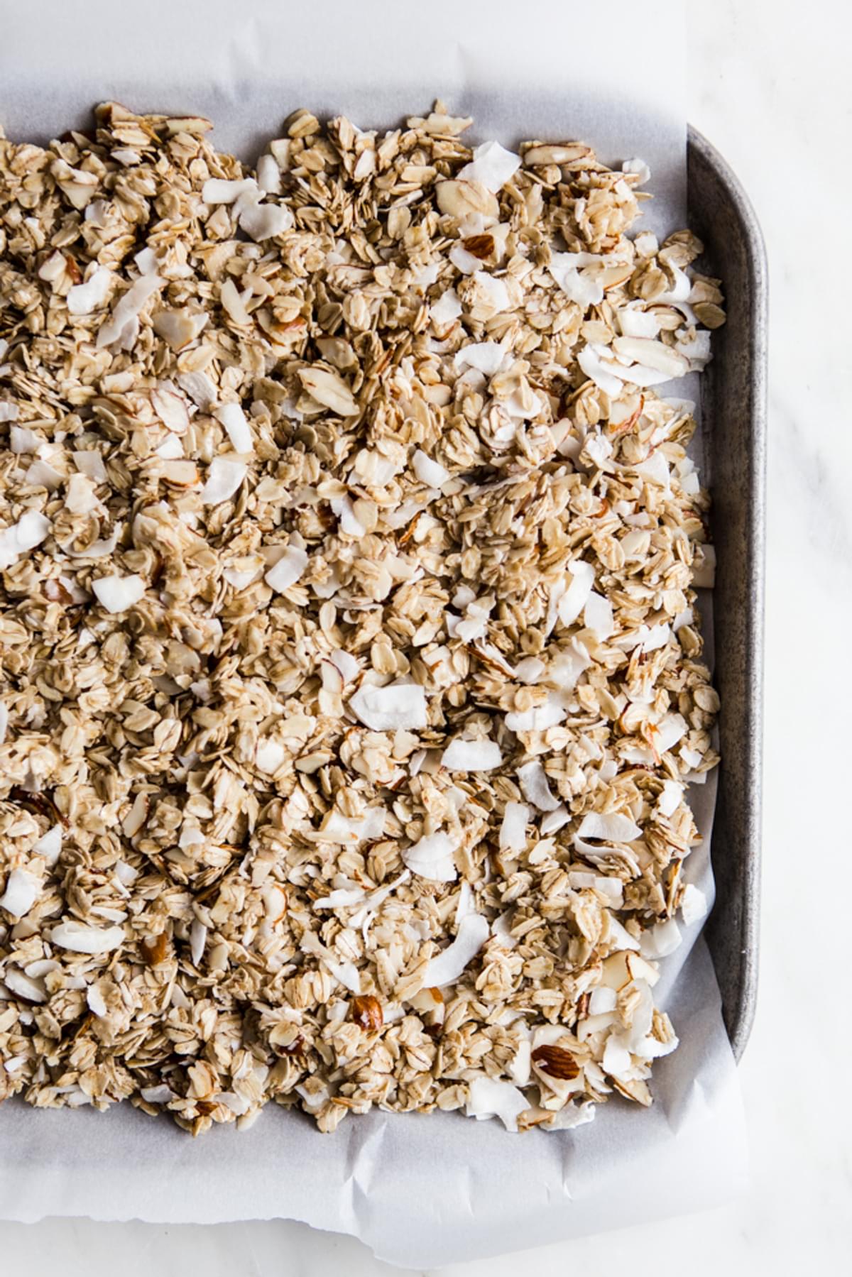 homemade Granola with Figs, Almonds and Coconut on a baking sheet with parchment paper