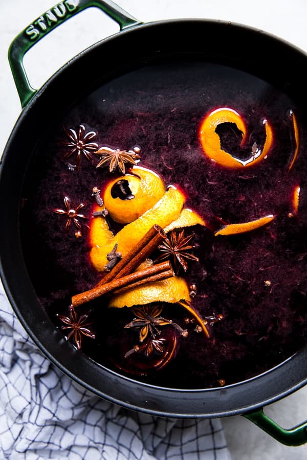 Large pot of warm mulled wine with orange peels, cinnamon and star anise.