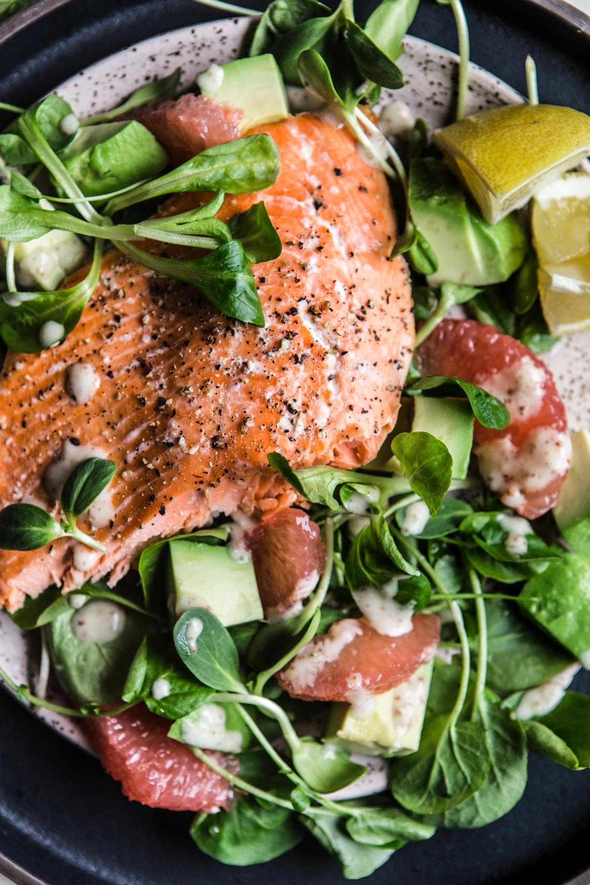 Close up of salmon and grapefruit salad with honey mustard dressing styled on a plate