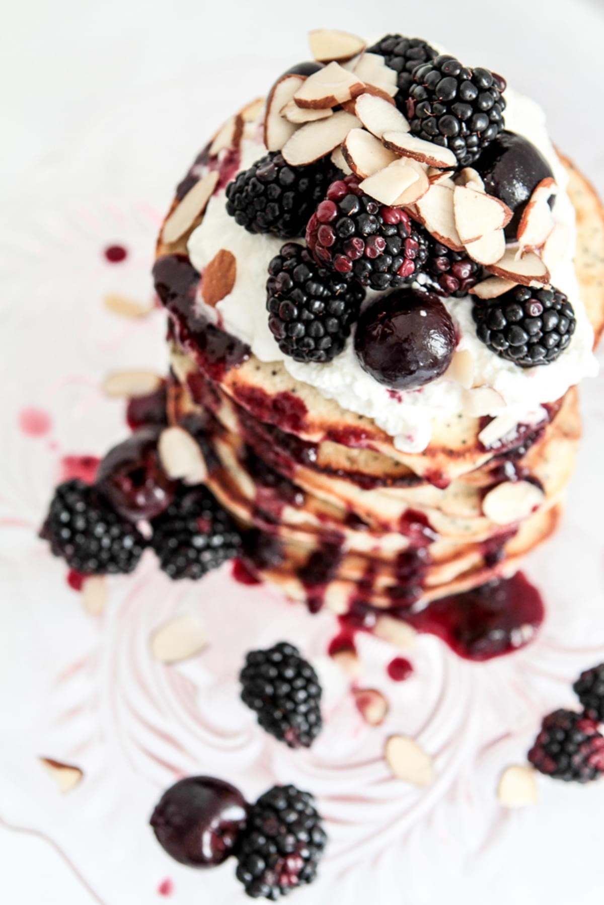 a stack of almond poppy seed pancakes with fresh berries