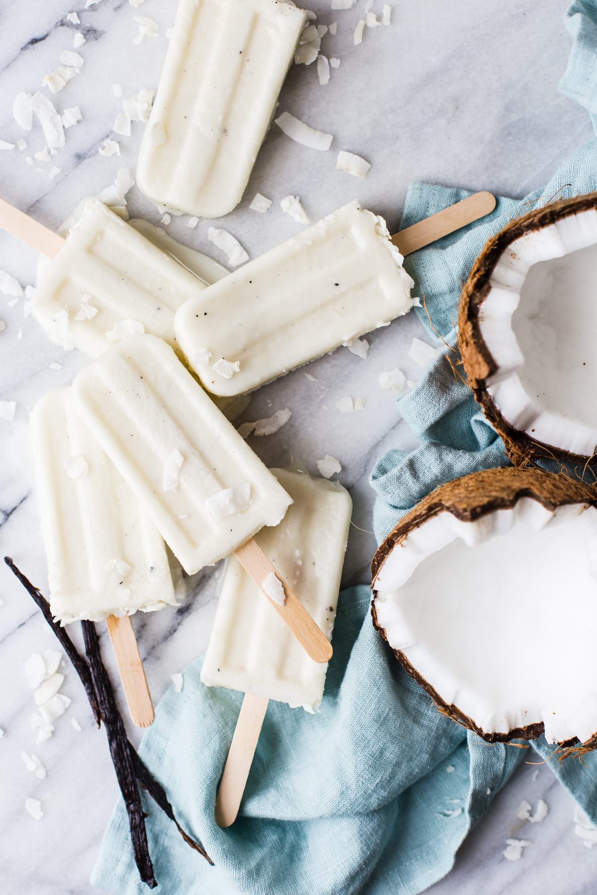 Coconut Cream Popsicles With Vanilla Bean And Malibu Rum next to an open coconut