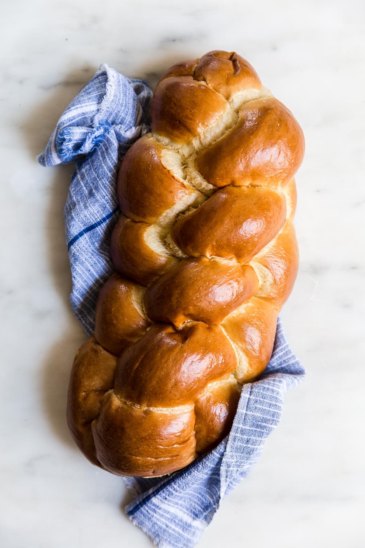 1 loaf of challah bread on a blue linen napkin