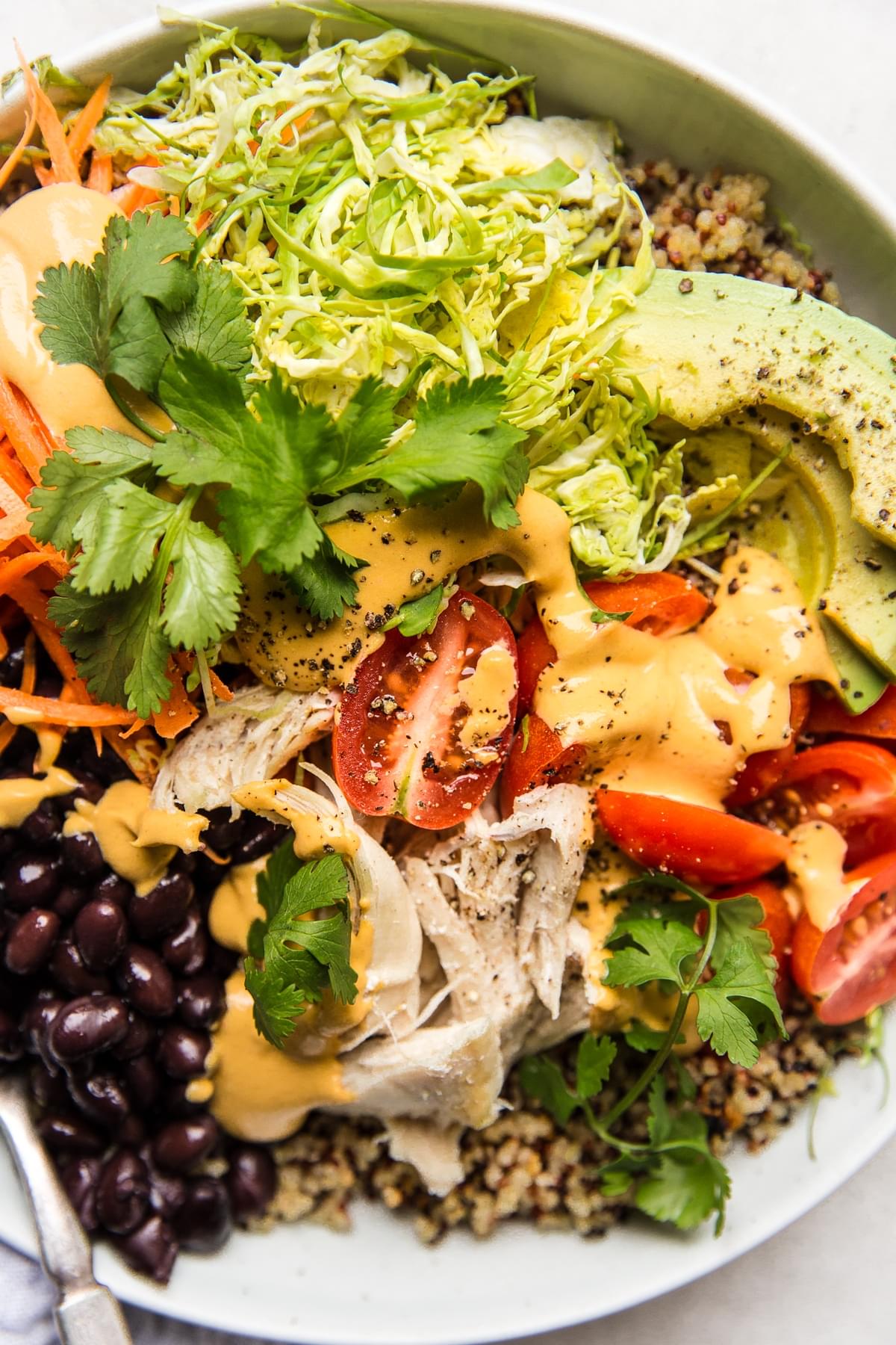 quinoa salad bowl with tomatoes black beans and chicken