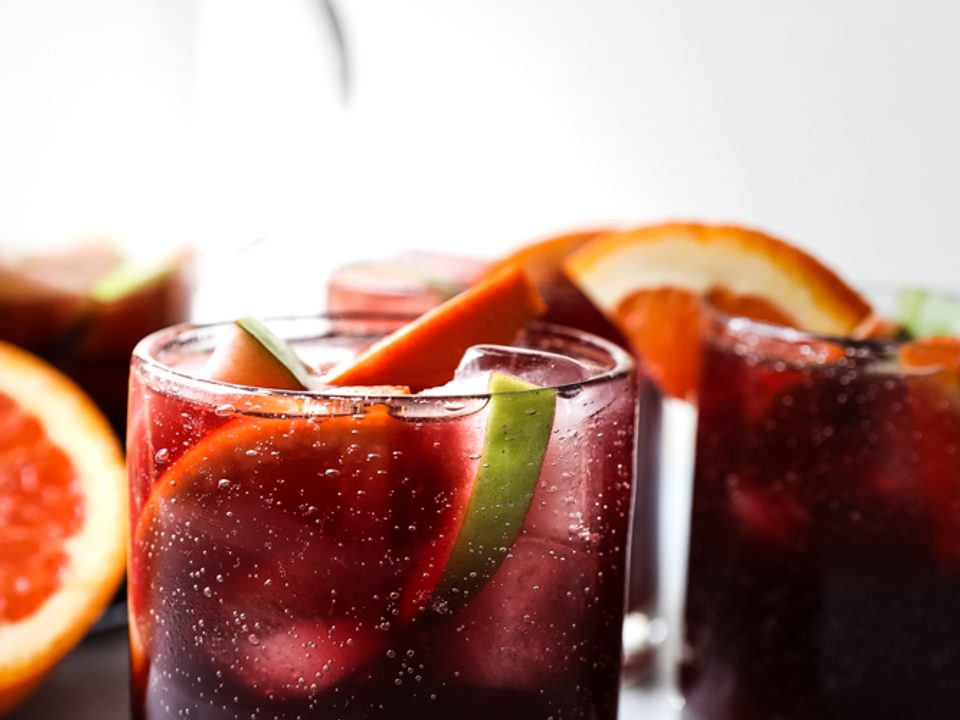 homemade sangria recipe in cups with apples and oranges