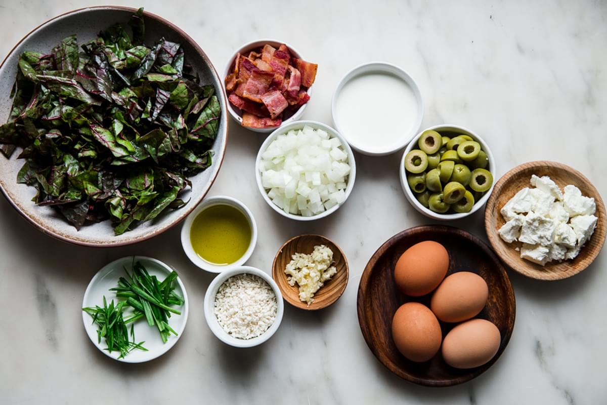 ingredients for Baked Eggs with Swiss Chard and Green Olives, bacon, onions chives breadcrumbs