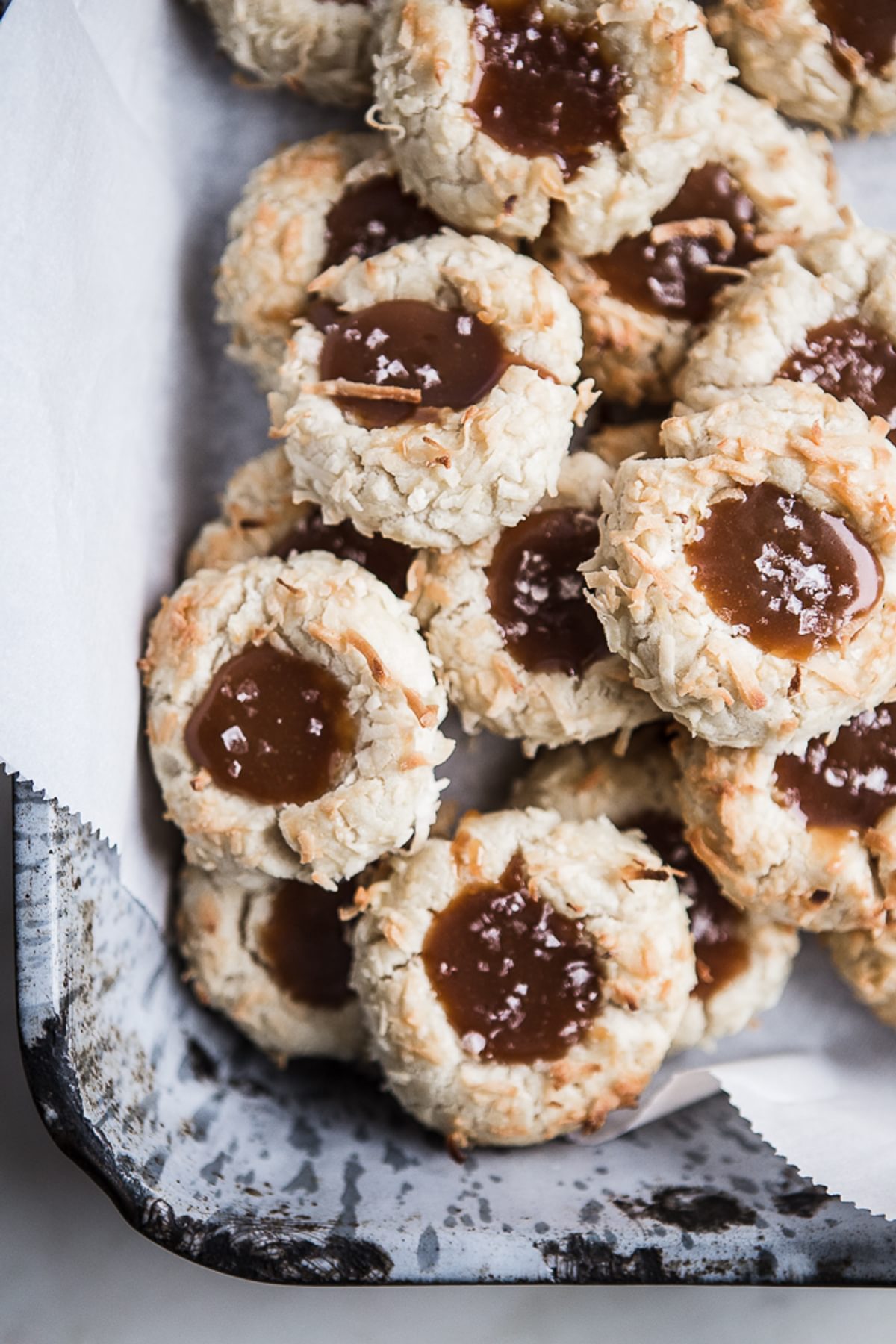 Coconut Thumbprint Cookies with Salted Caramel on parchment paper