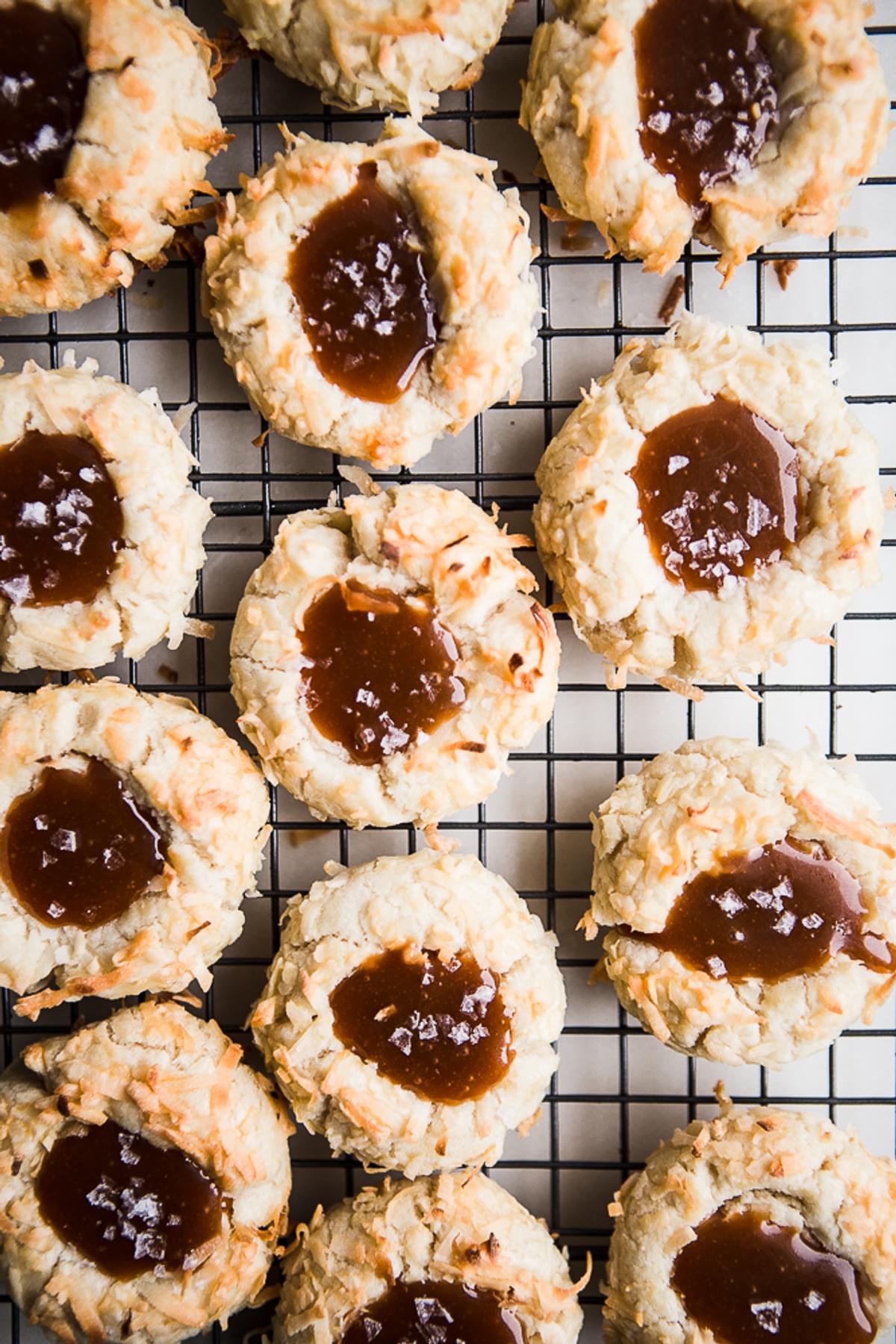 Coconut Thumbprint Cookies with Salted Caramel sauce on a cooling rack