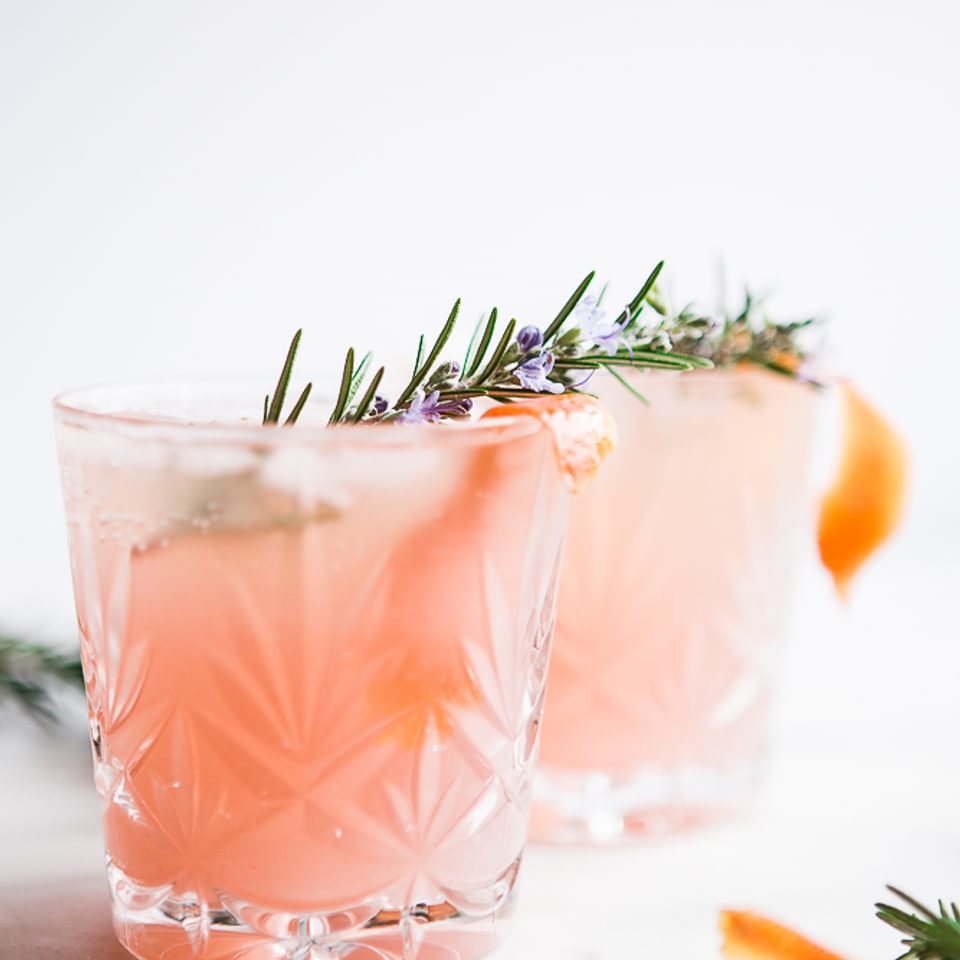 2 glasses of Grapefruit Cardamom Gin Fizz with rosemary