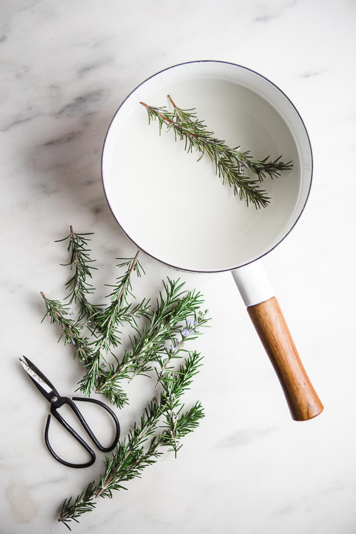 rosemary simple syrup in a small white pan