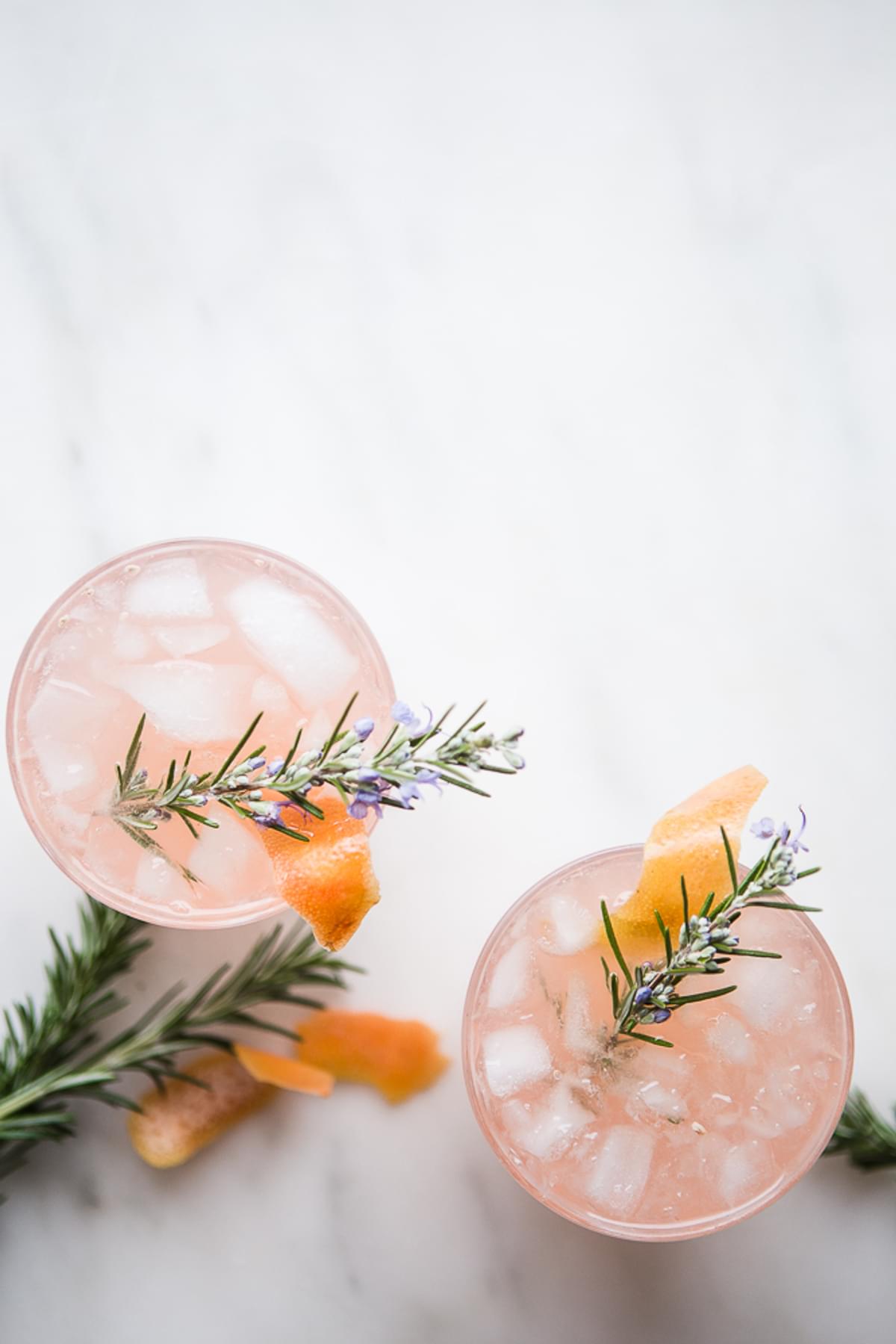 2 glasses of Grapefruit Cardamom Gin Fizz with rosemary