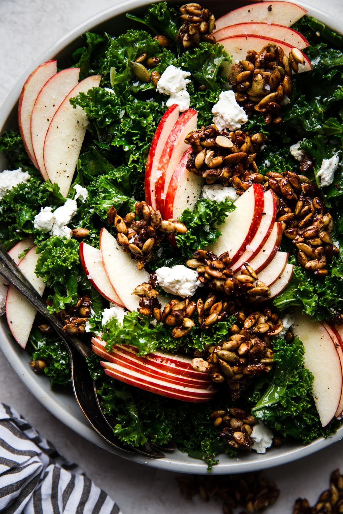 Kale Salad with Pumpkin Seed Clusters and apple slices in a bowl