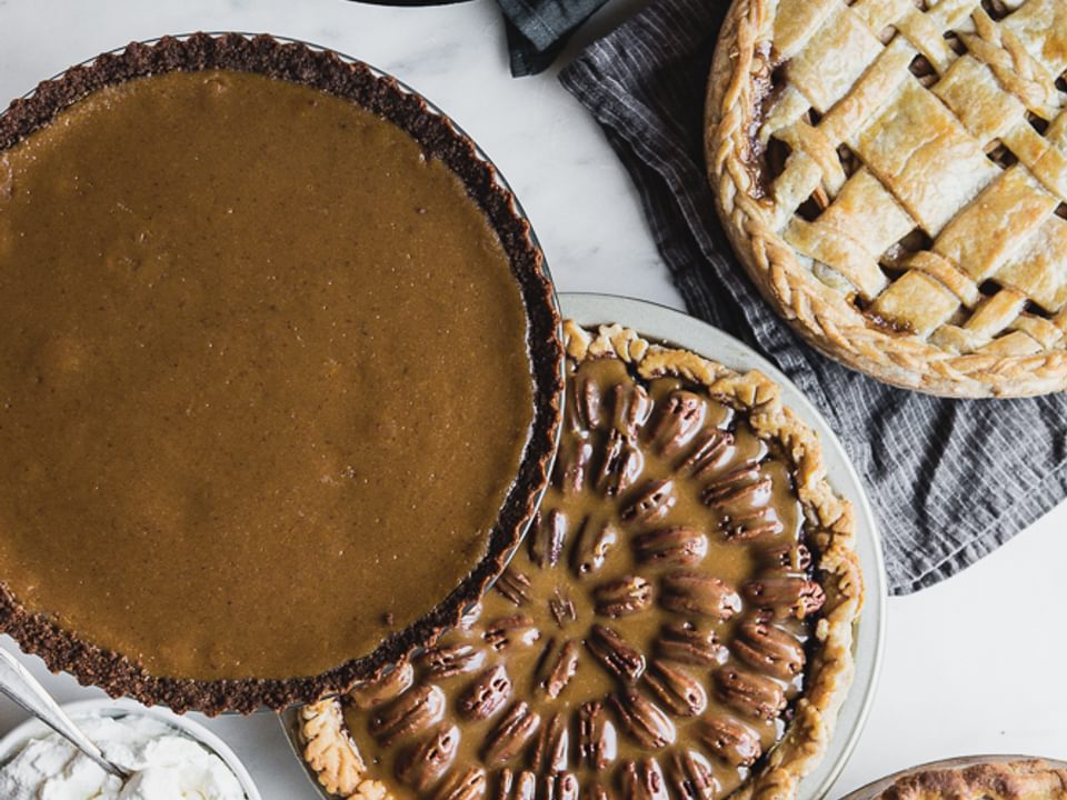 5 Thanksgiving pies on the table: pecan pie, apple pie, pumpkin pie
