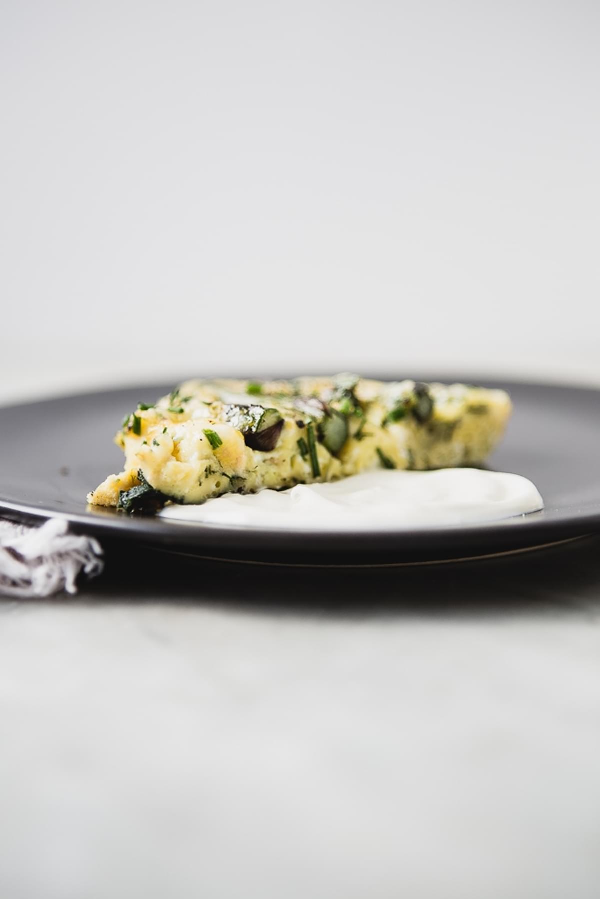 Slice of Spring Asparagus Frittata With Crème Fraîche on a plate