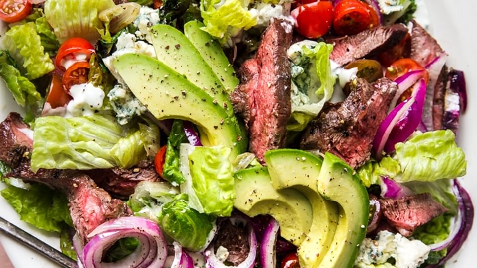 Grilled steak salad with homemade blue cheese dressing on a plate