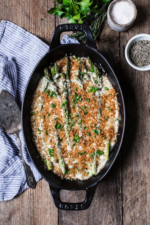 Asparagus Gratin with Gruyère and Panko baked in a cast iron baking dish garnished with parsley