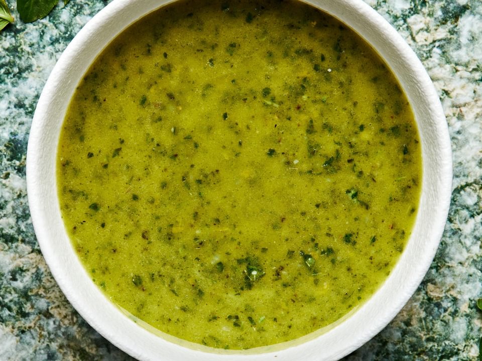 homemade basil vinaigrette in a small bowl made with garlic, lemon zest & Juice, basil, olive oil, sugar, salt and pepper