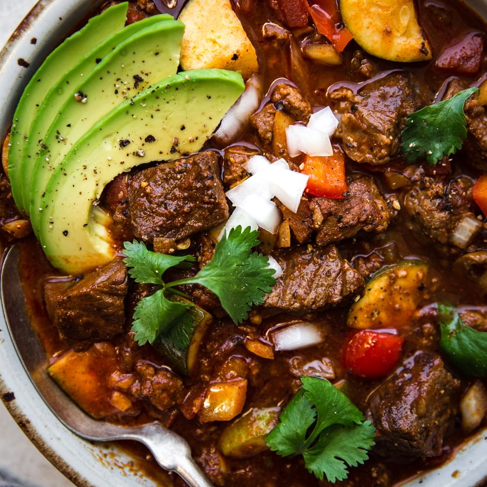 crockpot paleo chili in a bowl made with chuck roast, ground beef, zucchini and topped with avocado and cilantro