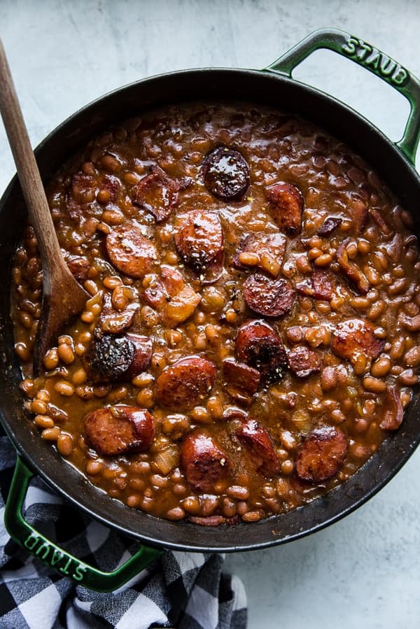 baked beans in a pot with made with extra ketchup, mustard, brown sugar and sausage.