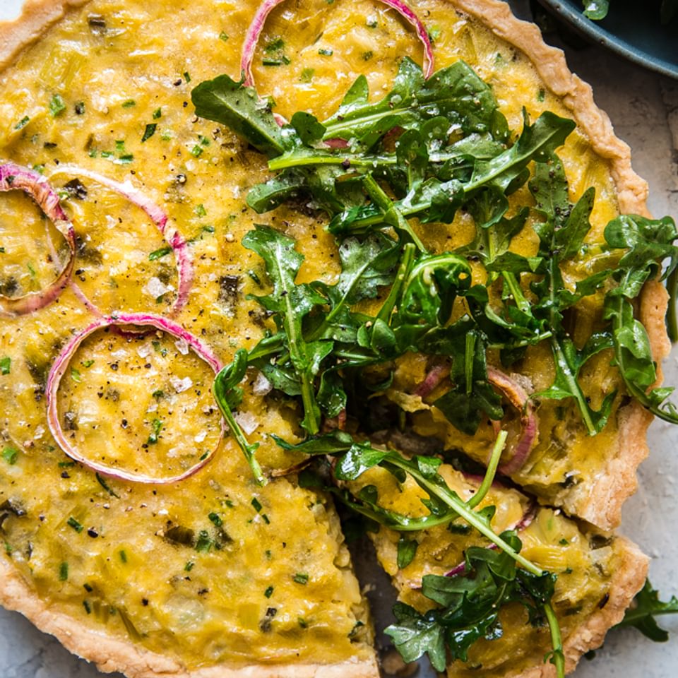Tart made with chives, red onions, leeks, topped with Arugula Salad