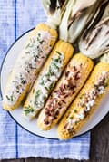 grilled corn on the cob with 4 toppings ideas on a plate