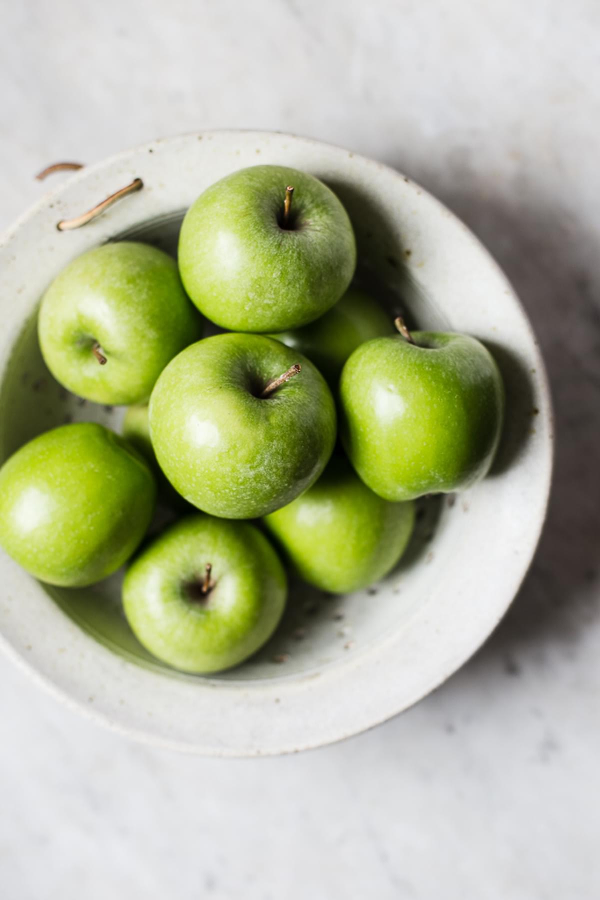 a bowl of granny smith apples