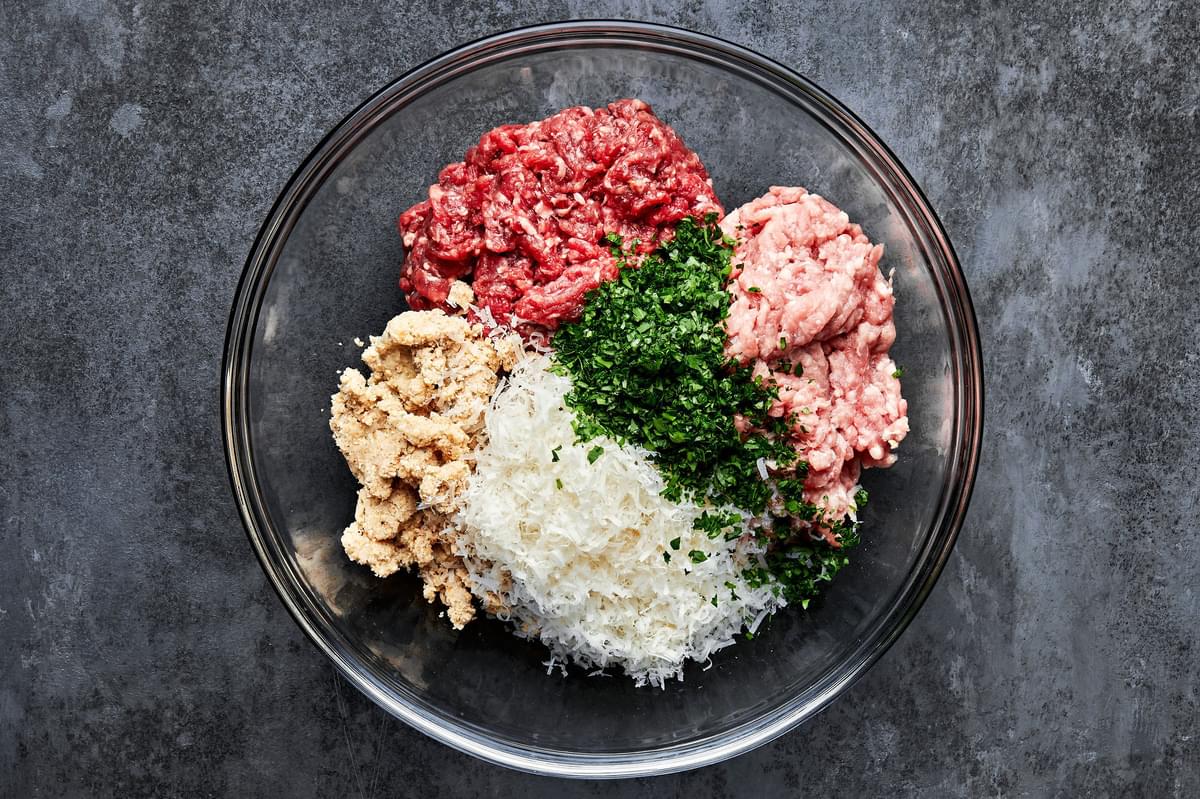 ground pork, ground beef, parsley, parmesan, heavy cream, breadcrumbs, garlic, salt, and pepper in a bowl for meatballs