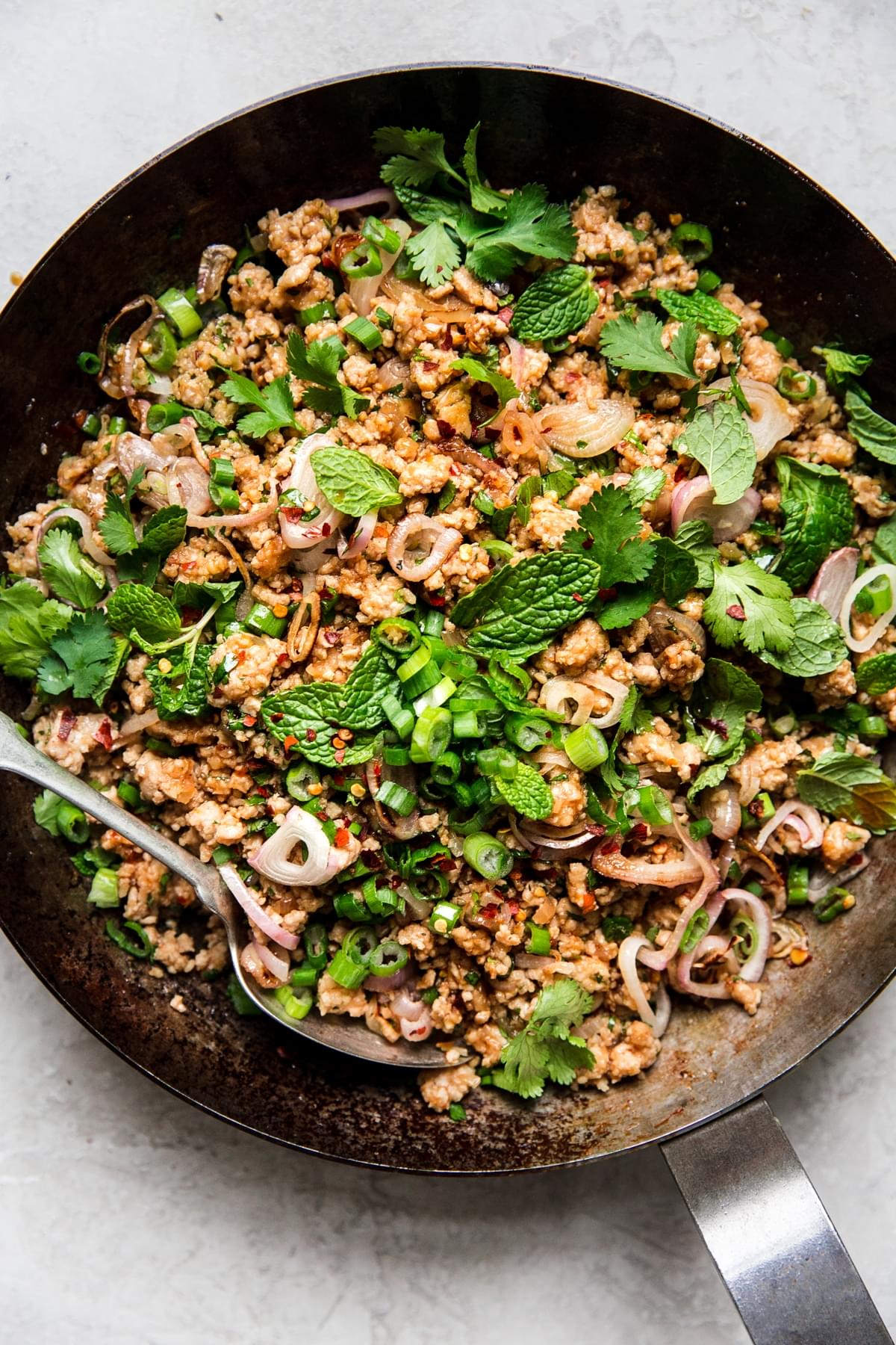 Larb Lettuce Cup filling in a pan ground chicken herbs with a spoon
