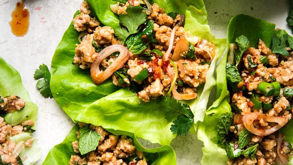 Larb Lettuce Cups with ground chicken a spoon with sauce