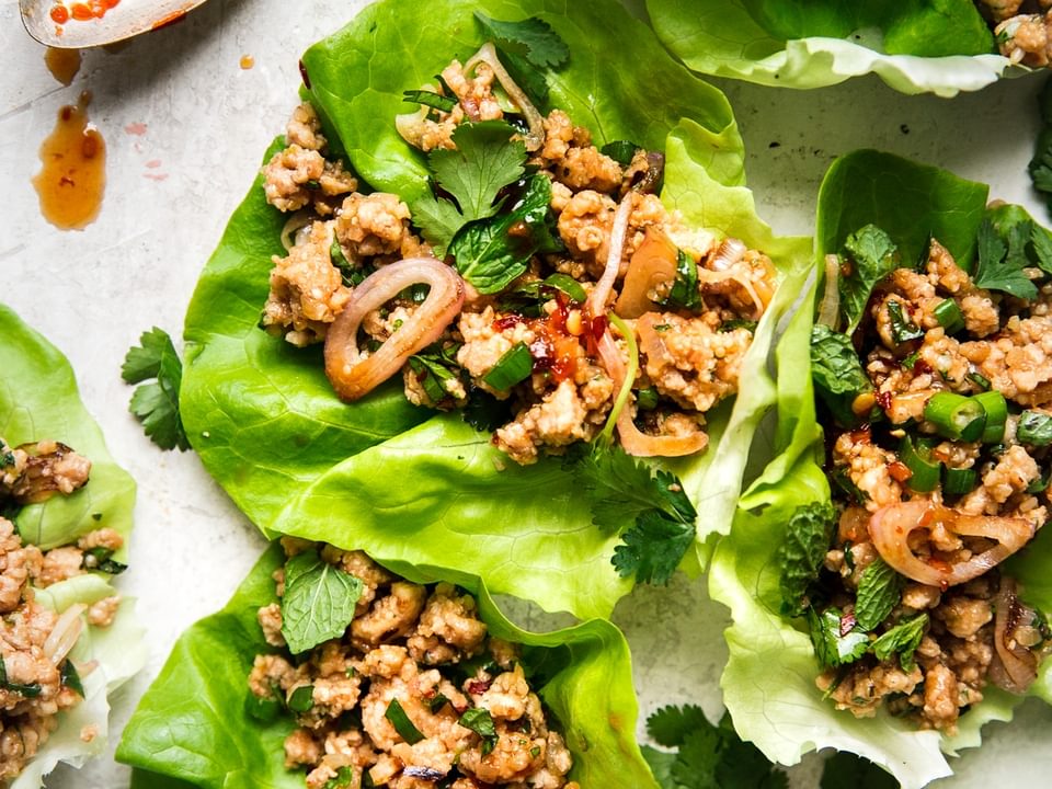 Larb Lettuce Cups with ground chicken a spoon with sauce