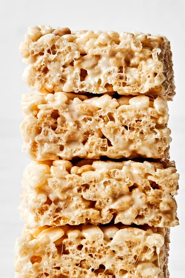 4 homemade rice crispy treats stacked on top of each other made with butter, marshmallows, vanilla and rice krispie cereal