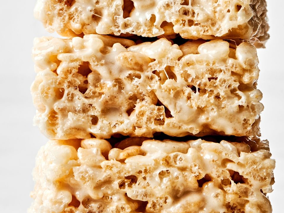 4 homemade rice crispy treats stacked on top of each other made with butter, marshmallows, vanilla and rice krispie cereal
