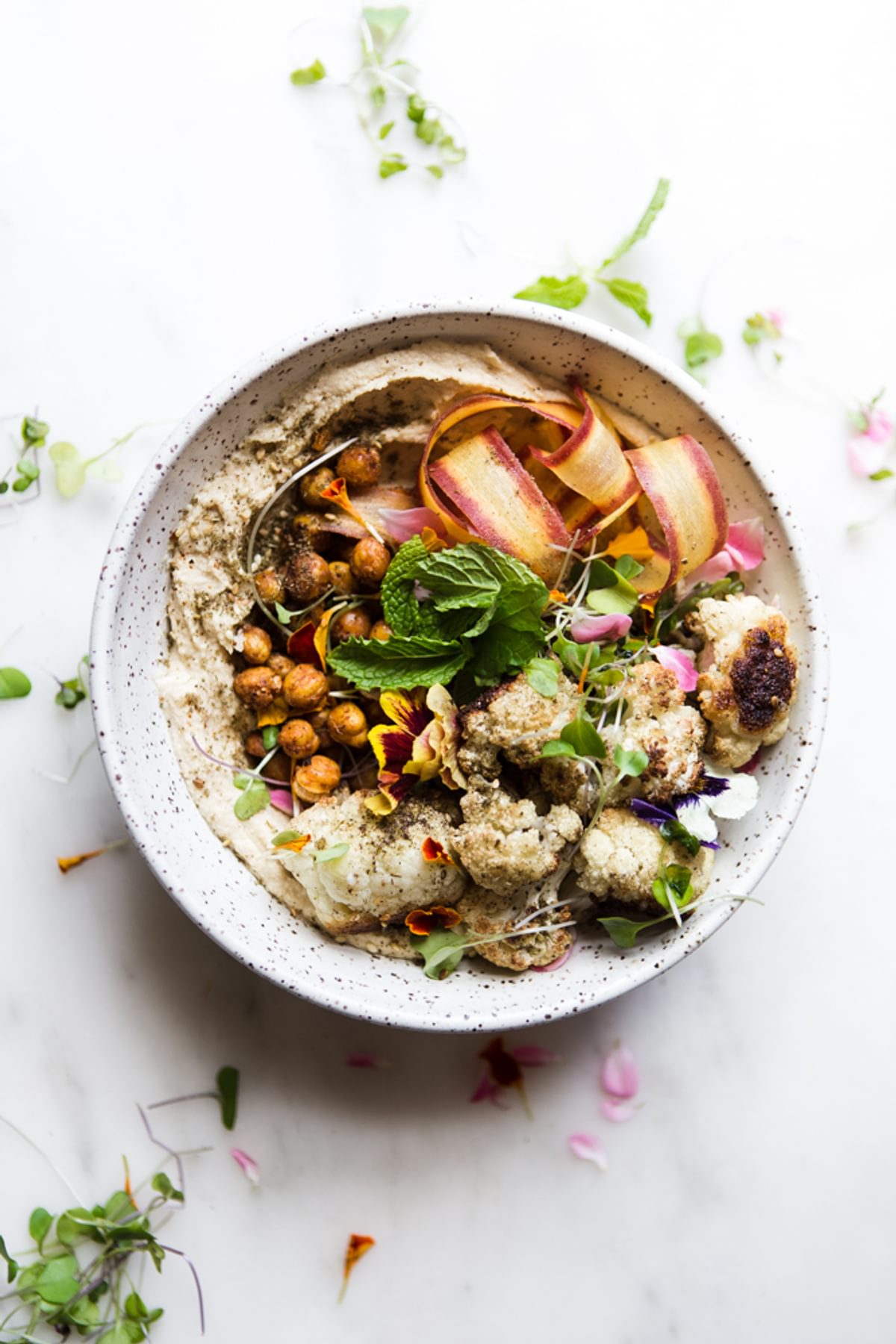 roasted cauliflower and hummus bowl with carrots, mint and spiced chickpeas.
