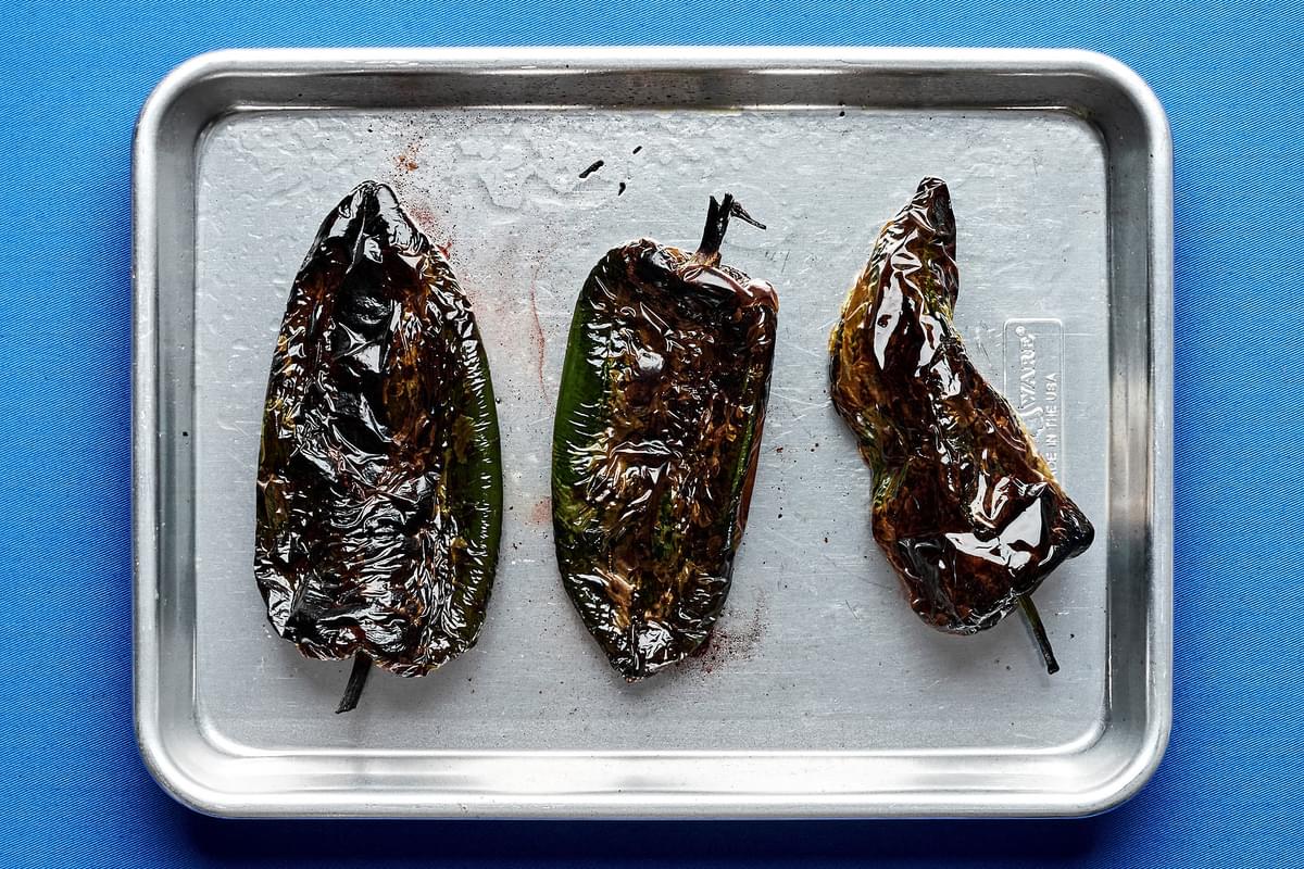 broiled poblano peppers brushed with olive oil on a baking sheet