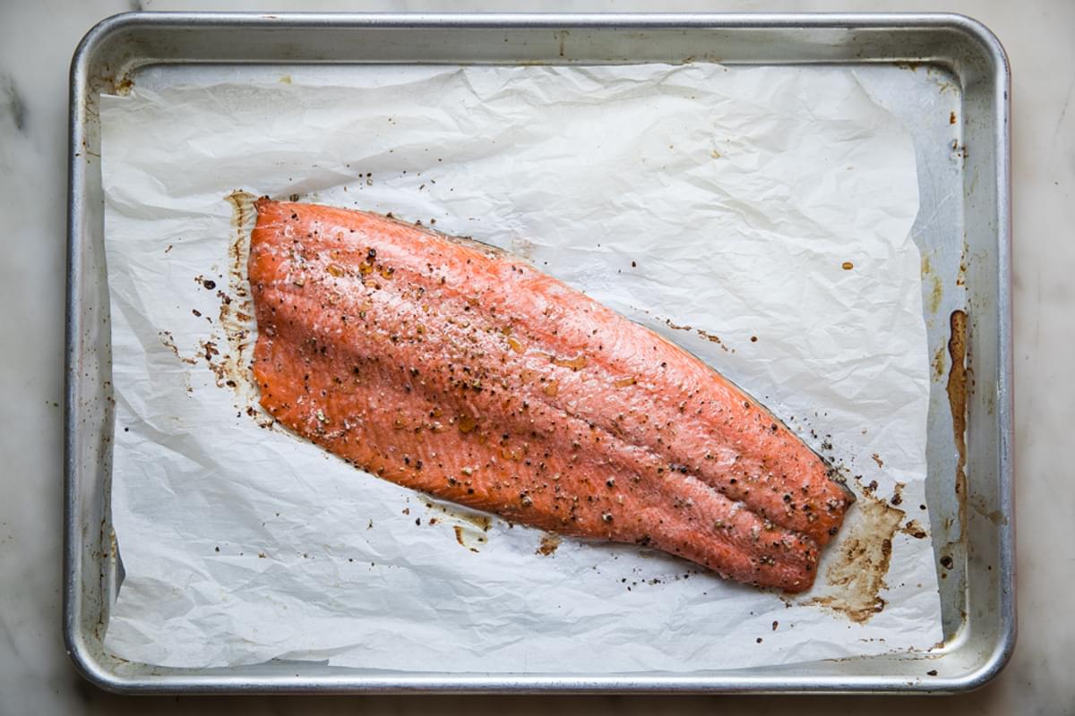 salmon fillet baked on a rimmed baking sheet with parchment