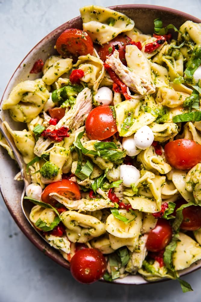 tortellini pasta salad with pesto, mozzarella, roasted red bell peppers, cherry tomatoes and shredded chicken