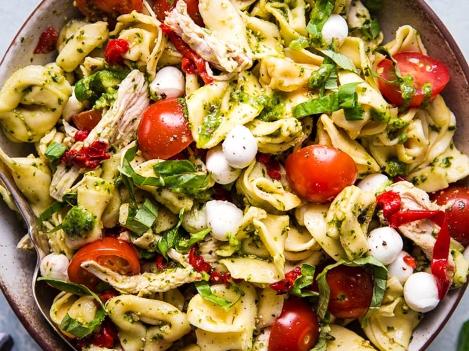 tortellini pasta salad with tomatoes, and basil and pesto