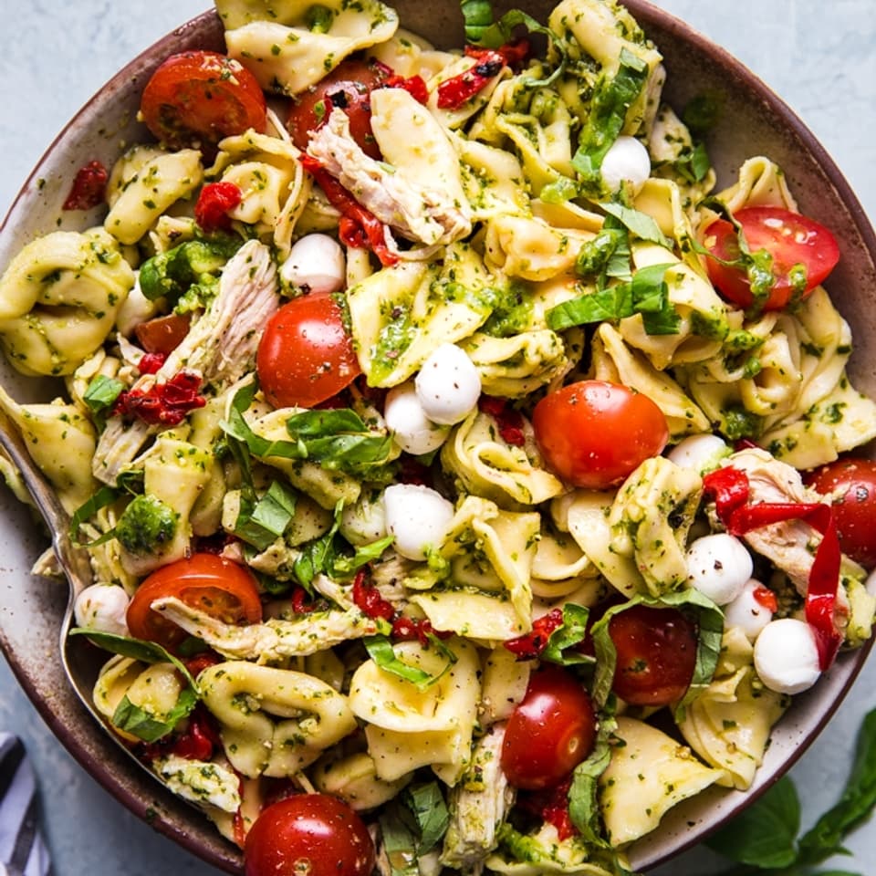 tortellini pasta salad with tomatoes, and basil and pesto