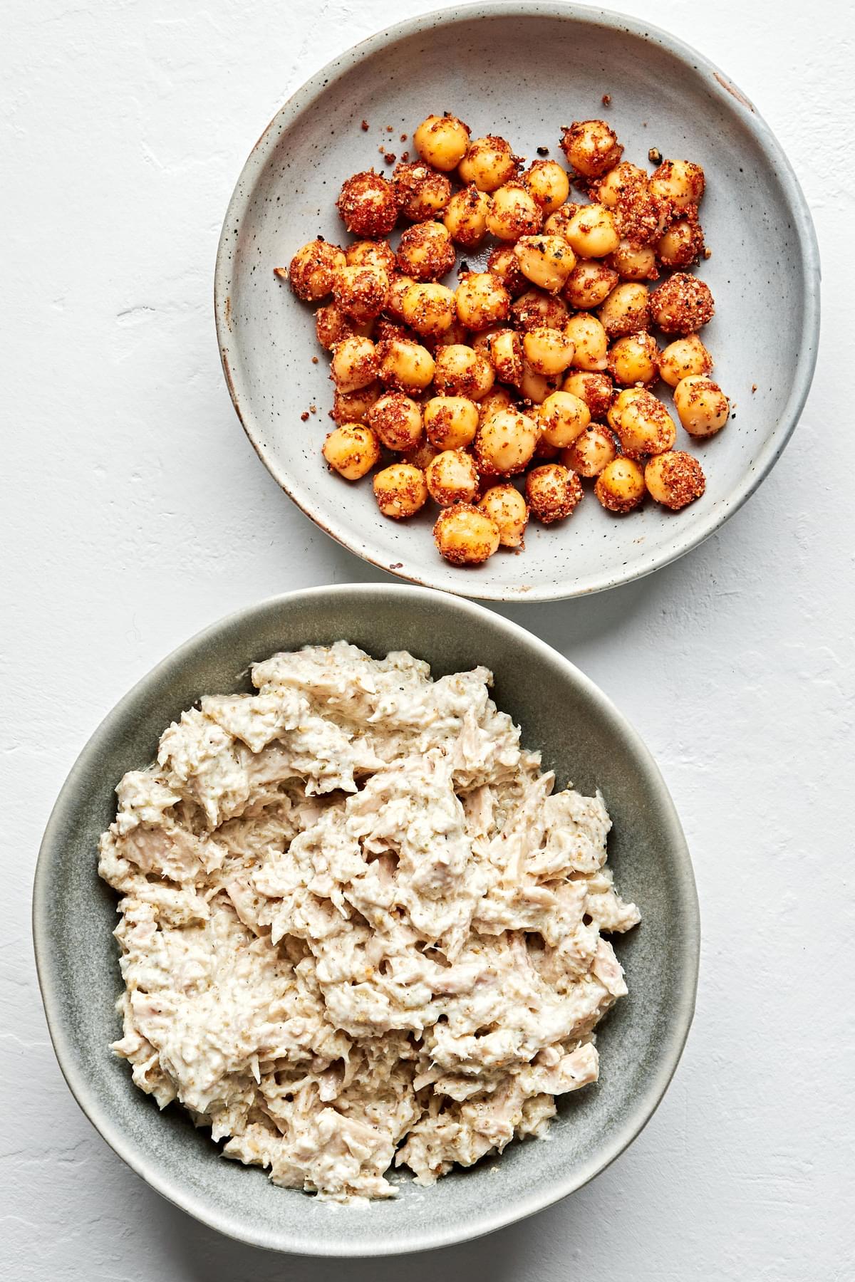 chickpeas tossed with salt, pepper, garlic powder, and smoked paprika in a bowl next to a bowl of tuna salad