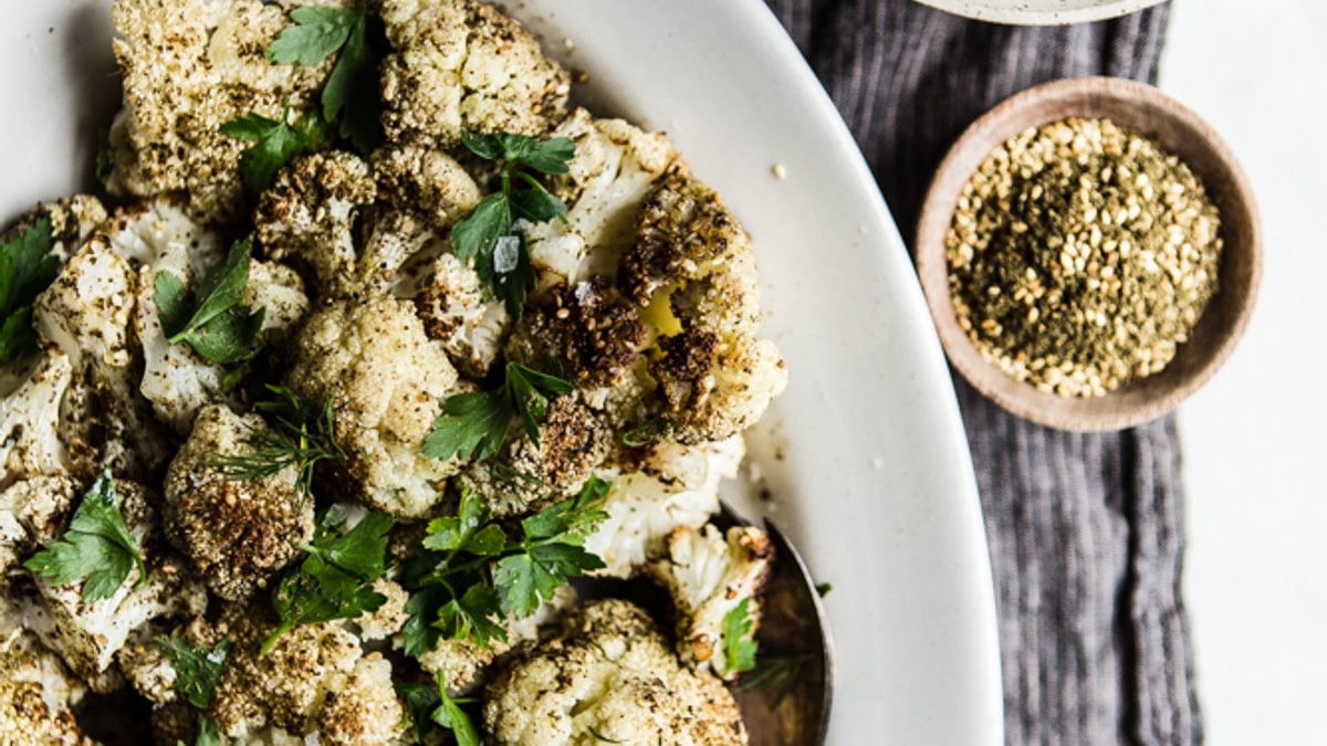 Za'atar Roasted Cauliflower on a plate with Herb Whipped Feta in a small bowl