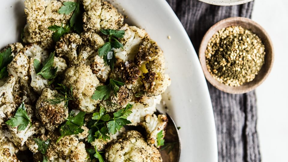 Za'atar Roasted Cauliflower on a plate with Herb Whipped Feta in a small bowl
