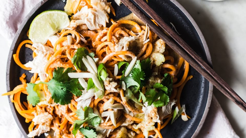 Pad Thai made with sweet potato noodles with cilantro and lime on a plate