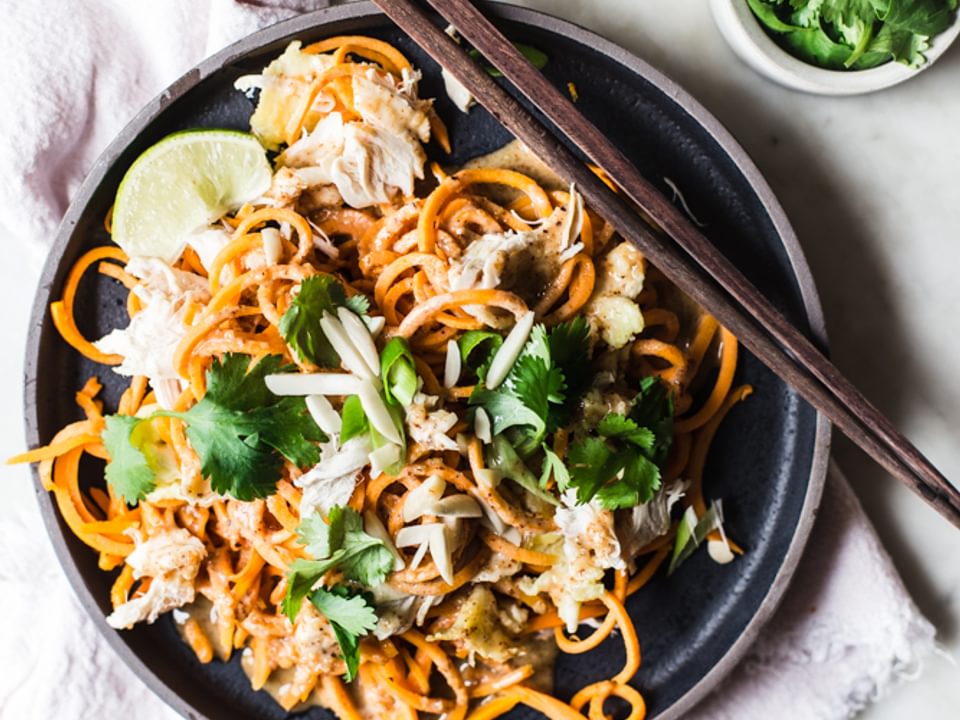 Pad Thai made with sweet potato noodles with cilantro and lime on a plate