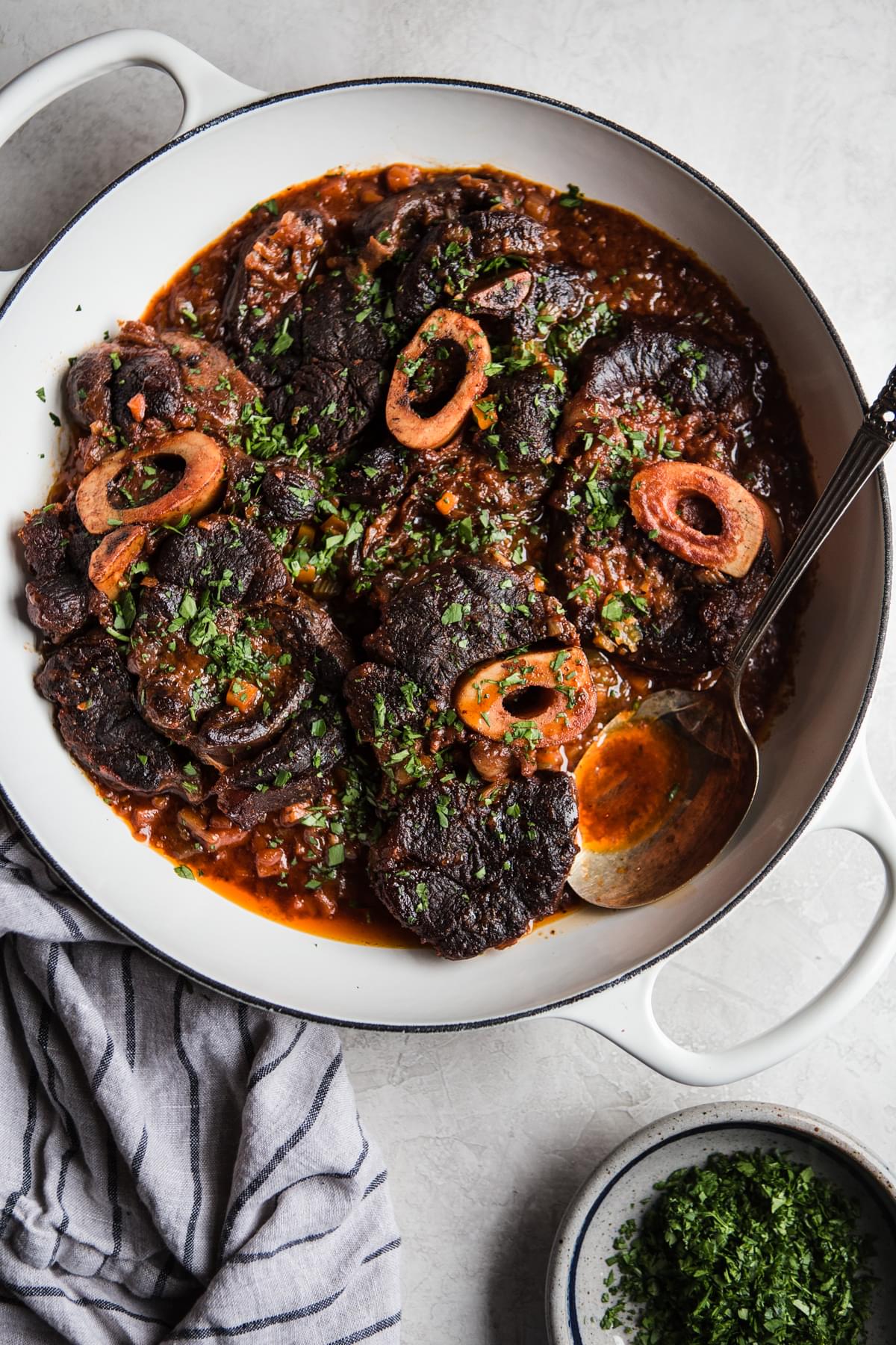 Italian osso buco cross cut beef shanks in a braiser with sauce
