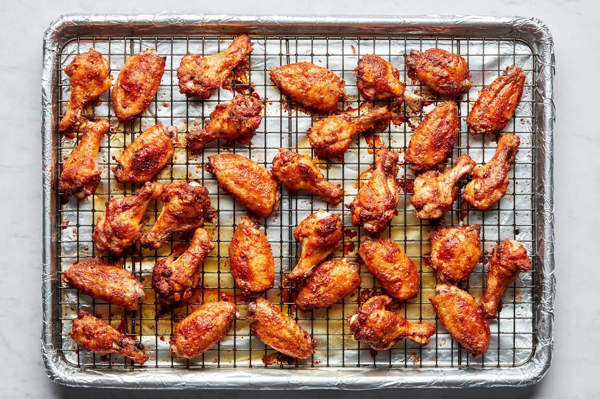 Homemade baked chicken wings seasoned with salt, pepper, garlic powder, paprika and cayenne on a cooling rack