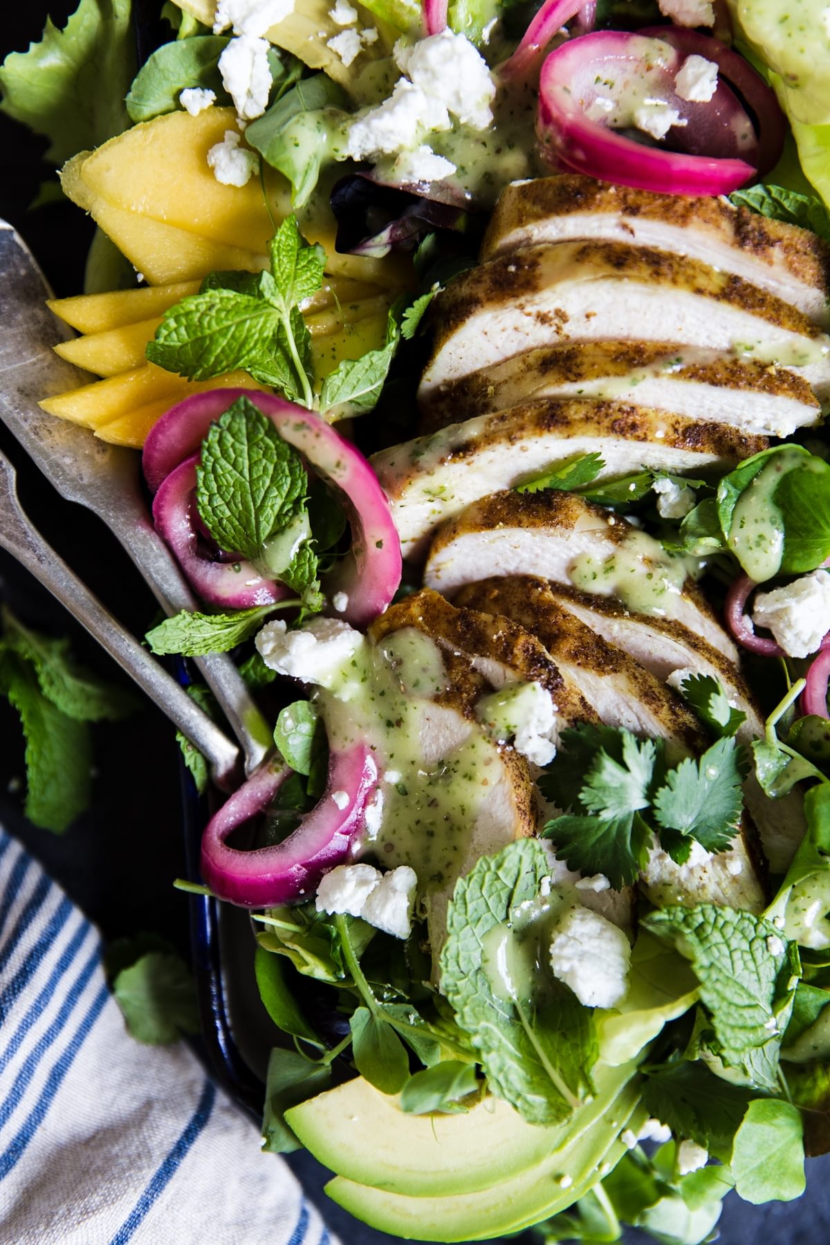 Grilled chicken salad with curry and mangos and pickled onions and avocado and mint